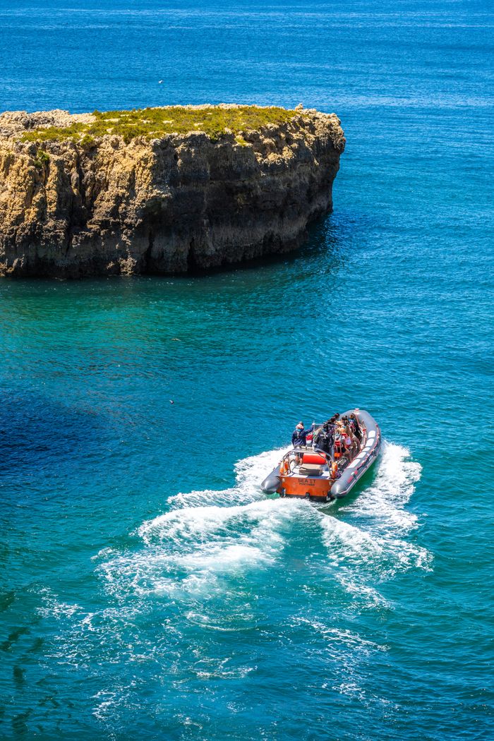pexels-photo-8289380-8289380 A thrilling speedboat tour navigating through the vibrant blue waters near Altura's rocky cliffs in Faro, Portugal.